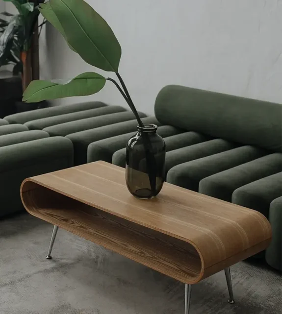 Designat väntrum med gröna soffor och träbord.